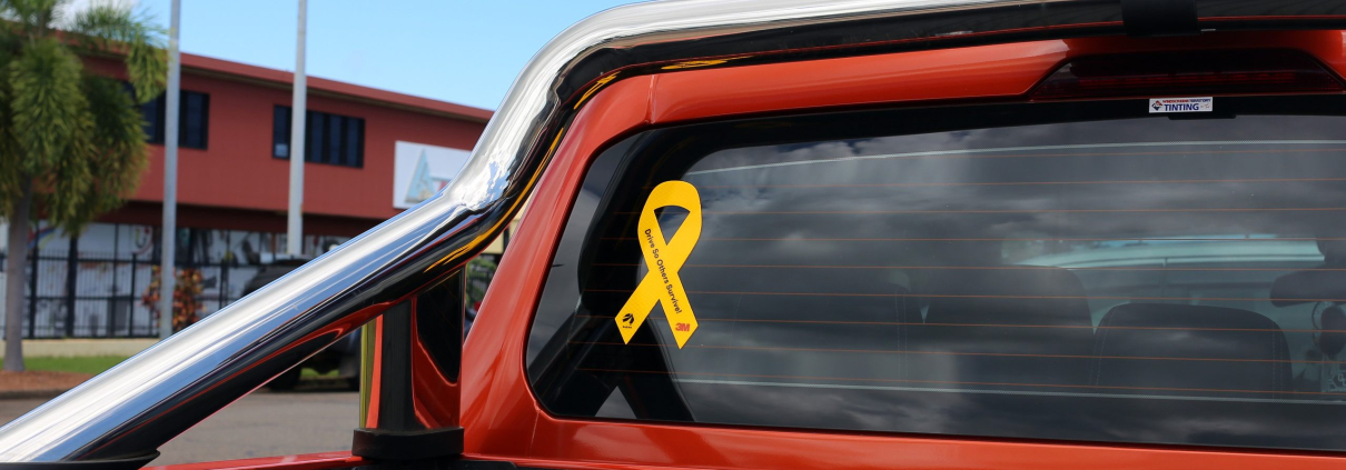 Yellow reflective ribbon is placed on the back of an orange work ute