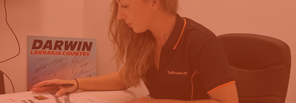Louise is sat at a desk working on paperwork.