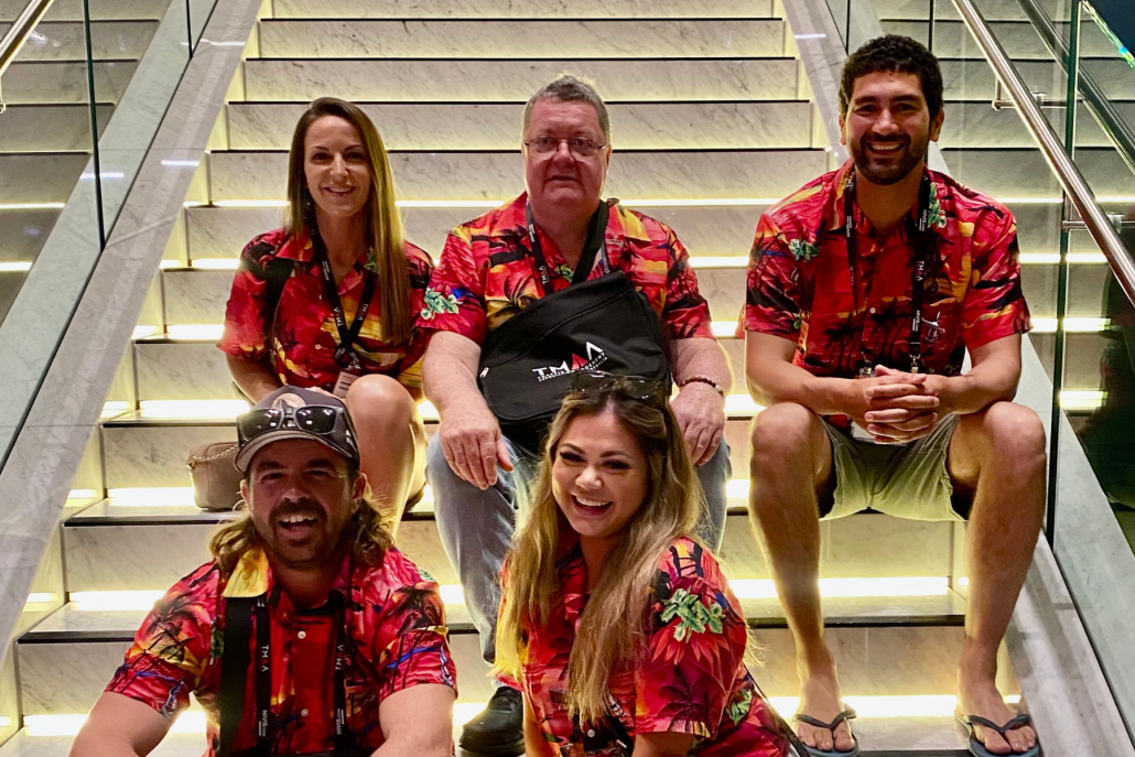 5 of our team members at the networking event. Sat on the stairs and matching in orange tropical shirts.