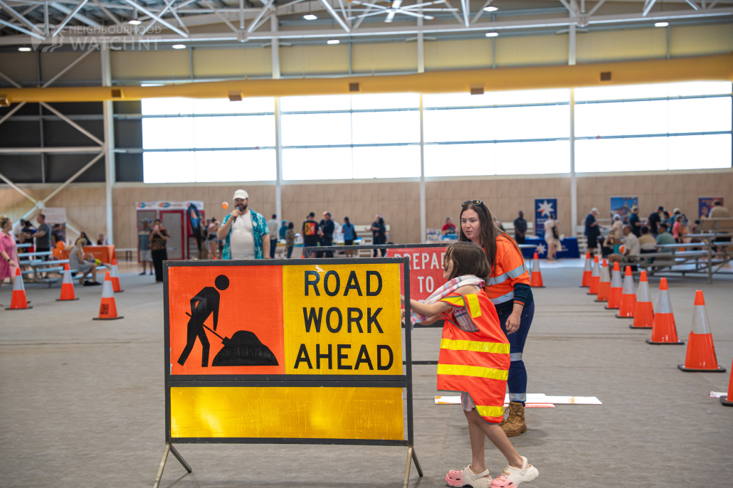 Multi message sign with our Traffic controller Nikita helping a chi9ld understand the role at the Darwin Safety Expo